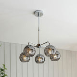 Draycott 5 Light Dimpled Glass Pendant in Chrome, five smoked mirrored globe shades on a chrome frame, hung from a ceiling rose in a bright room.
