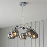 Draycott 5 Light Dimpled Glass Pendant in chrome, with five smokey mirrored globe shades on a chrome frame, shown hanging from a panelled ceiling.