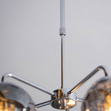 Close-up of the Draycott 5 Light Dimpled Glass Pendant in chrome, showing the ceiling plate with chrome arms and glass shades on a plain background.