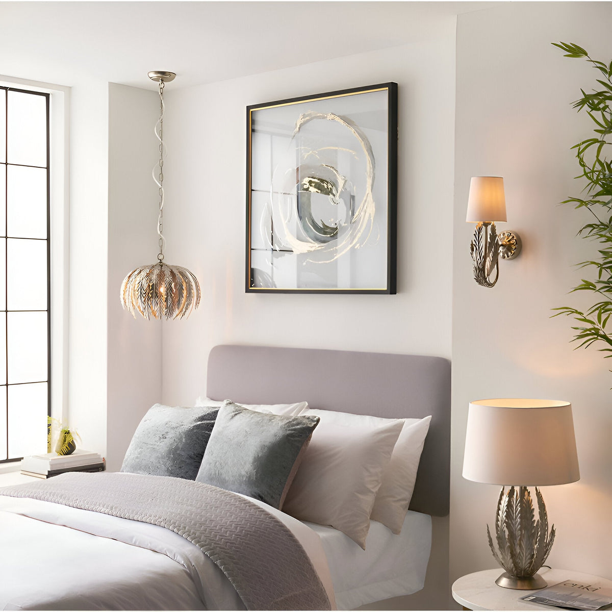 Endon Colette table lamp with layered silver leaf metal base and ivory cotton shade on a bedside table in a neutral bedroom setting.