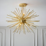 Endon Merrick 6 light semi-flush ceiling light with brass sunburst spike design and exposed G9 lamps, mounted below a white ceiling above panelled walls.