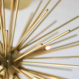Close-up of the Endon Merrick 6 Light Semi-Flush Ceiling Light showing radiating brass spikes and a lit G9 lamp against a pale background.