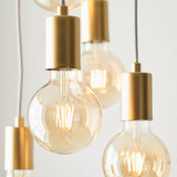 Marlowe 6 Light Pendant in gold, close-up of cylindrical metal holders and amber globe bulbs on grey fabric flex against a plain white background.