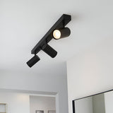 Calder 3 Light Spotlight Plate in matt black metal, angled ceiling fitting with GU10 heads, shown lit on a white ceiling.