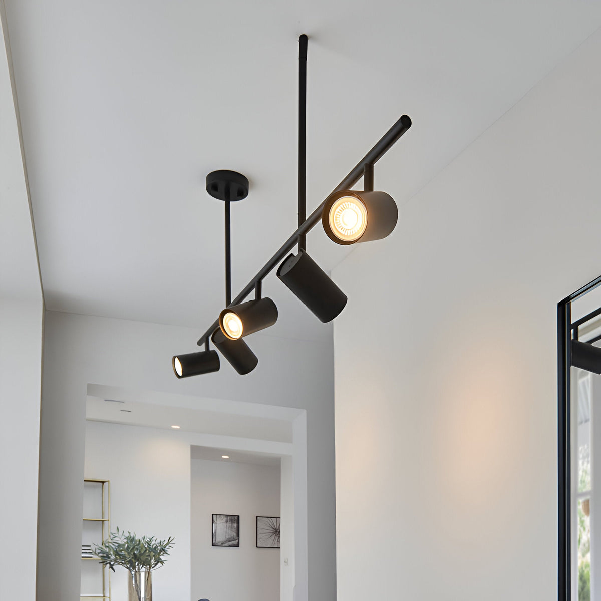 Calder 5 Light Spotlight Bar in matt black, angled metal bar with five adjustable GU10 heads, shown ceiling-mounted in a hallway setting.