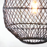 Close-up of the Endon Chartdale pendant showing its hand-woven black rattan shade in an open diamond weave with a lit E27 filament bulb inside.