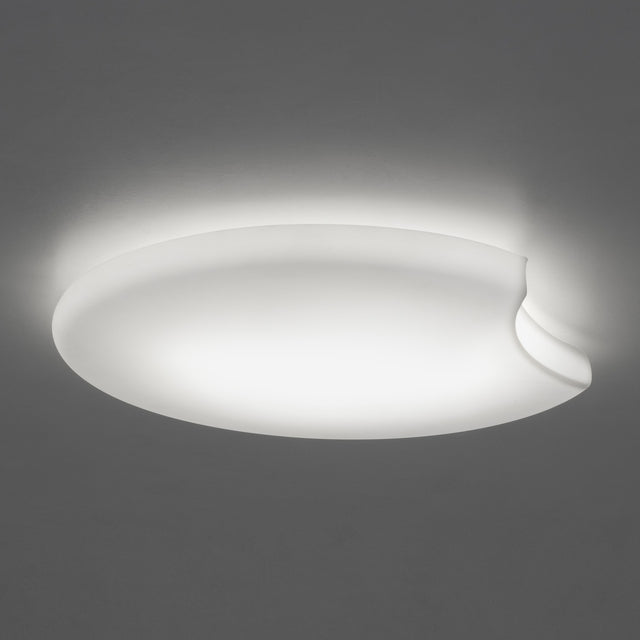 Moon LED Flush Ceiling Light in white, a large round disc with a curved notch cut into one edge, glowing softly against a plain grey background.