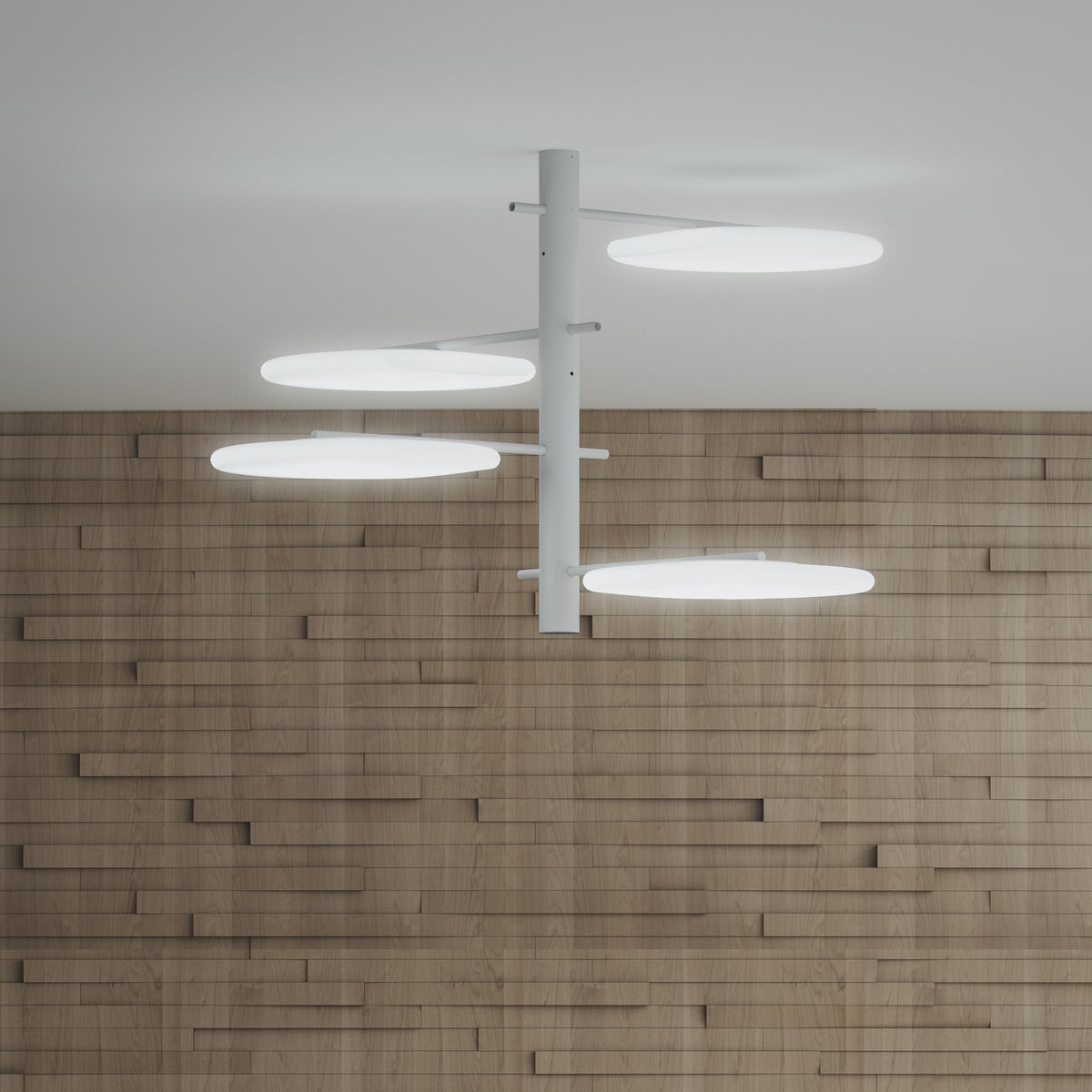 SuperMoon LED semi-flush ceiling light with white vertical stem and four staggered arms holding round crescent-cut discs, mounted on a plain ceiling above a wood-panelled wall.