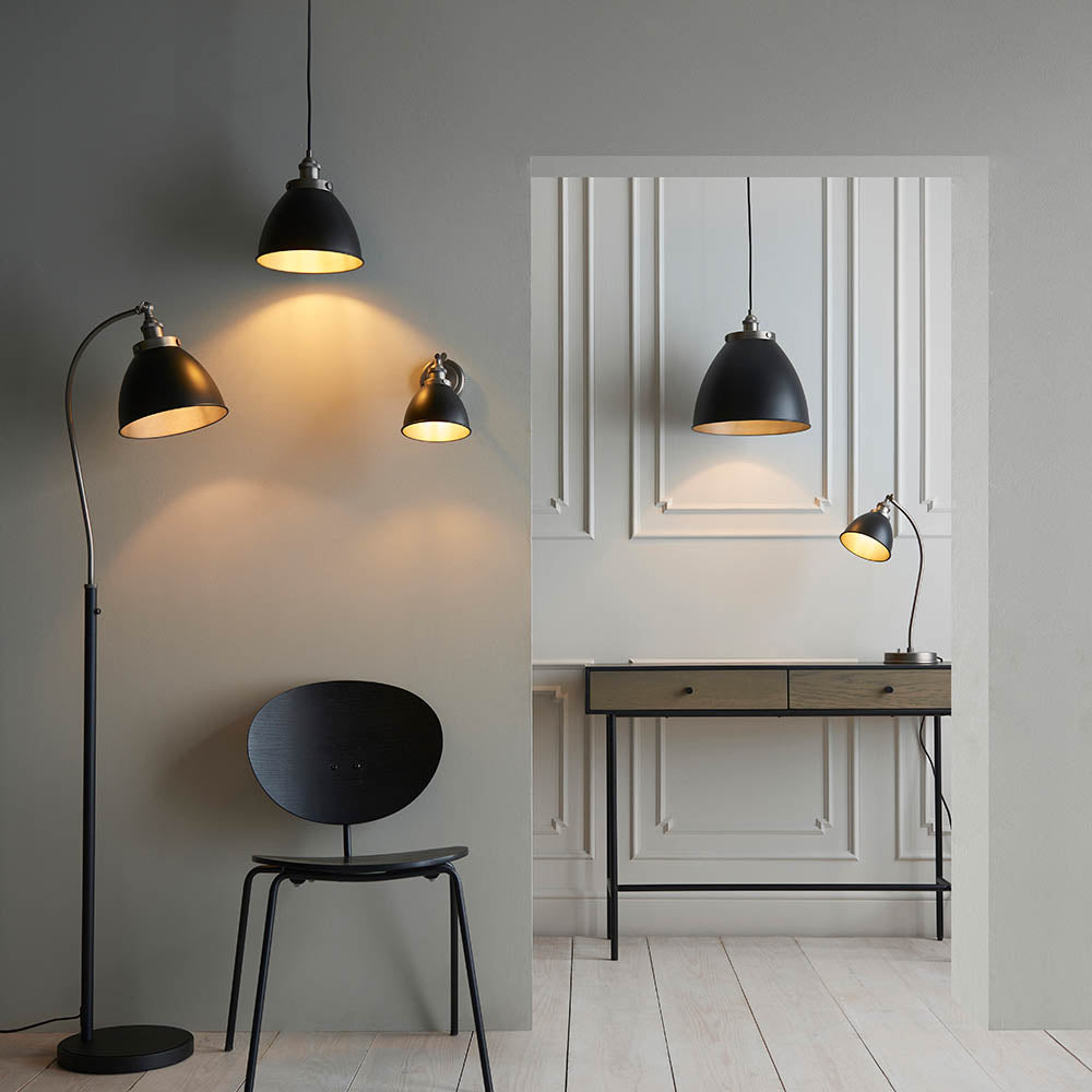 Endon Bramdale small pendant in matt black with aged pewter detailing, shown with a matching wall light, floor lamp and desk lamp in a styled interior.