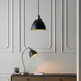 Endon Bramdale small pendant in matt black with aged pewter detailing, shown with a matching table lamp on a wooden sideboard against panelled grey walls.