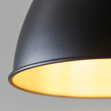 Close-up of the Endon Bramdale Small Pendant in matt black, showing the rolled-edge metal shade and aged pewter inner glowing around the E27 lamp.