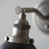 Close-up of the Endon Bramdale wall light's aged pewter knuckle joint, knurled socket collar and matt black shade with thumbscrew fittings.
