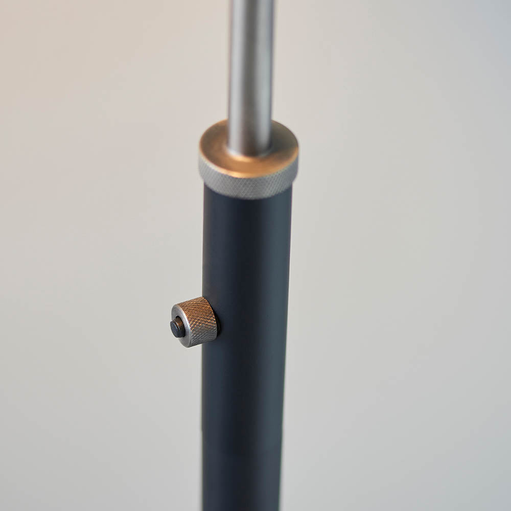 Close-up of the Bramdale Floor Lamp's adjustable black metal pole with silver knurled collar and locking screw, shown against a plain light background.