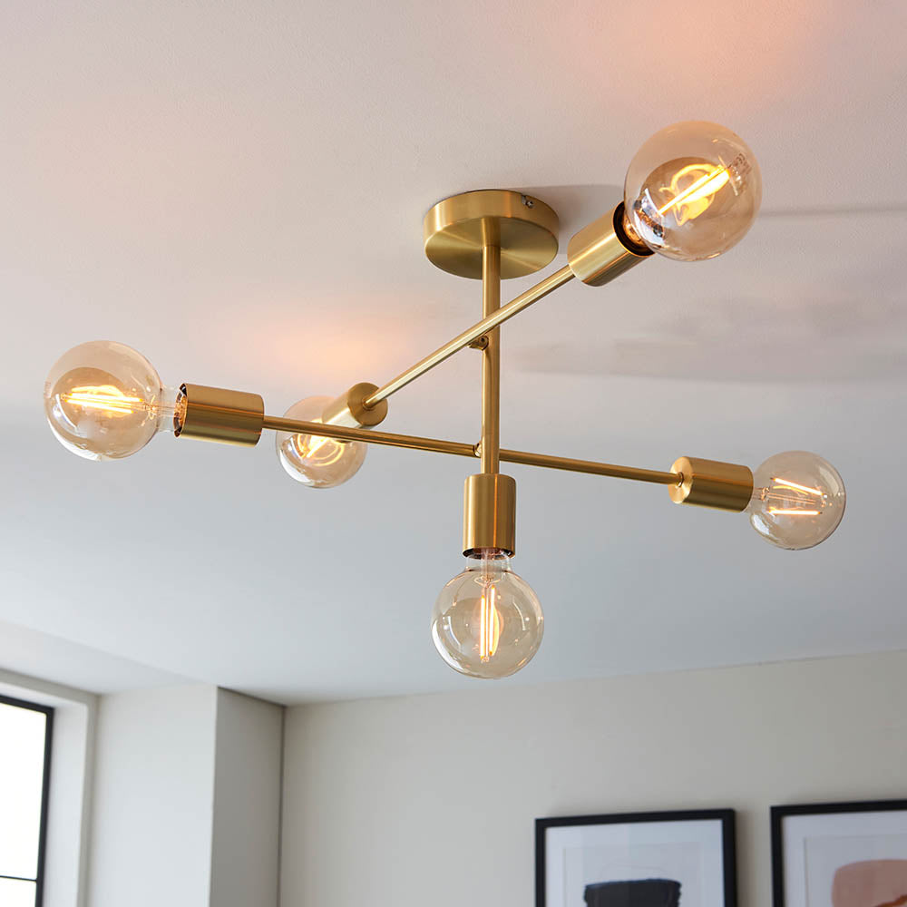 Endon Marlowe 5 Light Semi-Flush Ceiling Light in satin brass, with five angled arms holding exposed globe bulbs, mounted on a white ceiling.