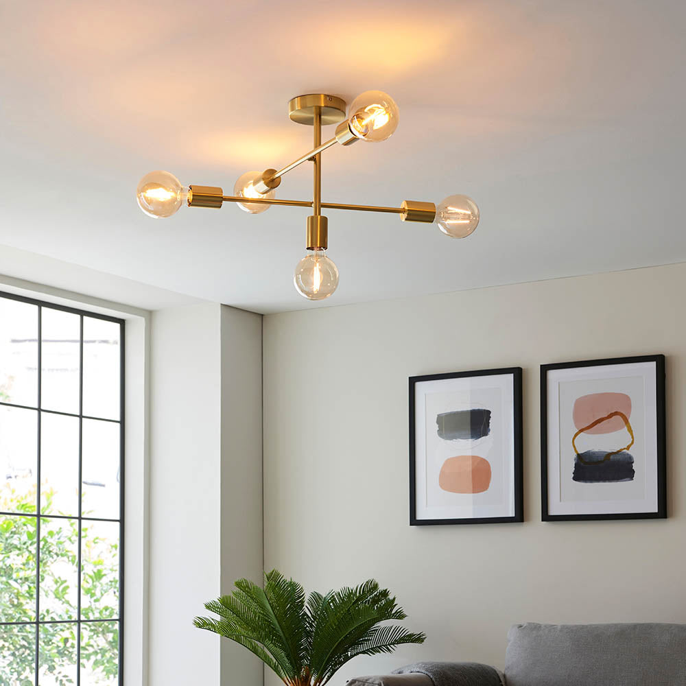 Endon Marlowe 5 Light semi-flush ceiling light in satin brass with angled arms and exposed E27 globe bulbs, installed in a modern living room.