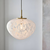 Calloway Pendant in brass and white, a single-light dome fixture with speckled confetti glass shade and satin brass fittings, shown lit.