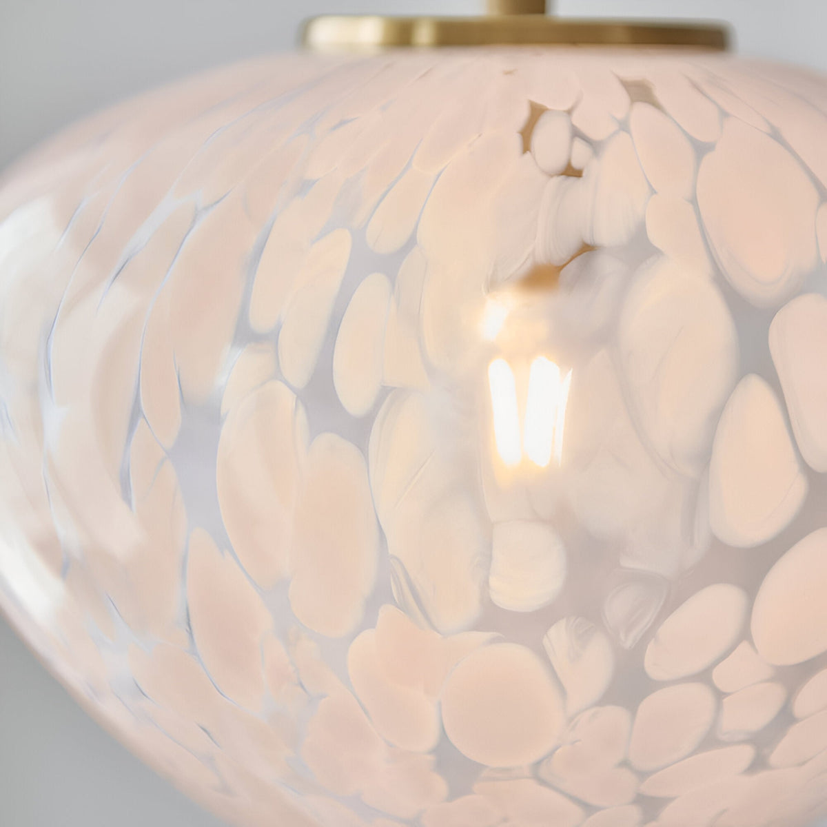 Close-up of the Calloway Pendant in Brass & White, showing the mottled white confetti glass shade with satin brass fitting and illuminated E27 bulb inside.