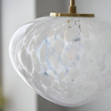 Close-up of the Calloway Pendant in brass and white, showing a rounded glass shade with a speckled confetti effect and satin brass ceiling mount.