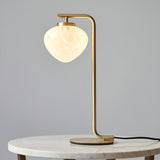 Endon Calloway table lamp in satin brass with a white confetti blown glass shade, shown on a round marble side table against a grey background.