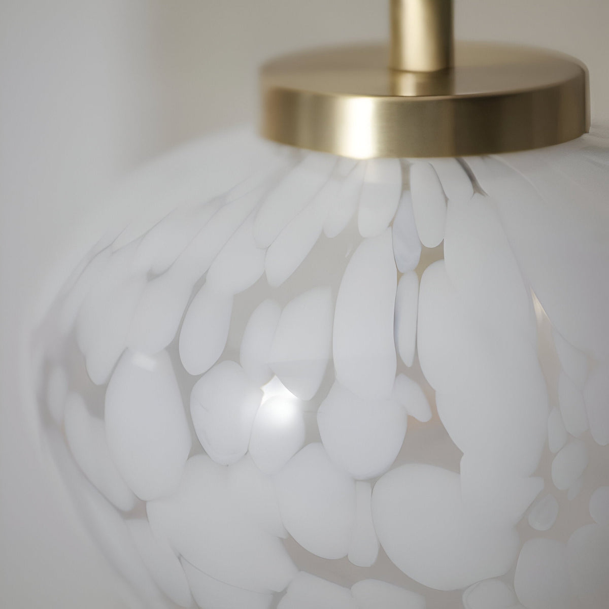 Close-up of the Endon Calloway table lamp showing the satin brass cap and white confetti blown glass shade.