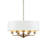 Endon Brenley V1 6 light pendant with a wide white drum shade, gold-lined interior, antique brass multi-arm frame and suspension chain on a white background.