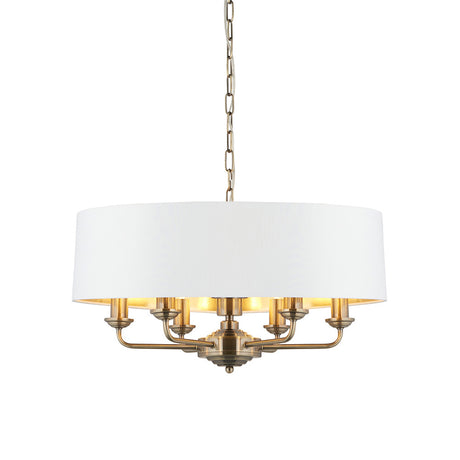 Endon Brenley V1 6 light pendant with a wide white drum shade, gold-lined interior, antique brass multi-arm frame and suspension chain on a white background.