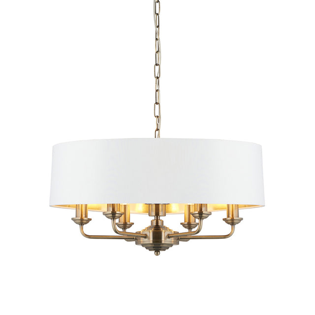Endon Brenley V1 6 light pendant with a wide white drum shade, gold-lined interior, antique brass multi-arm frame and suspension chain on a white background.