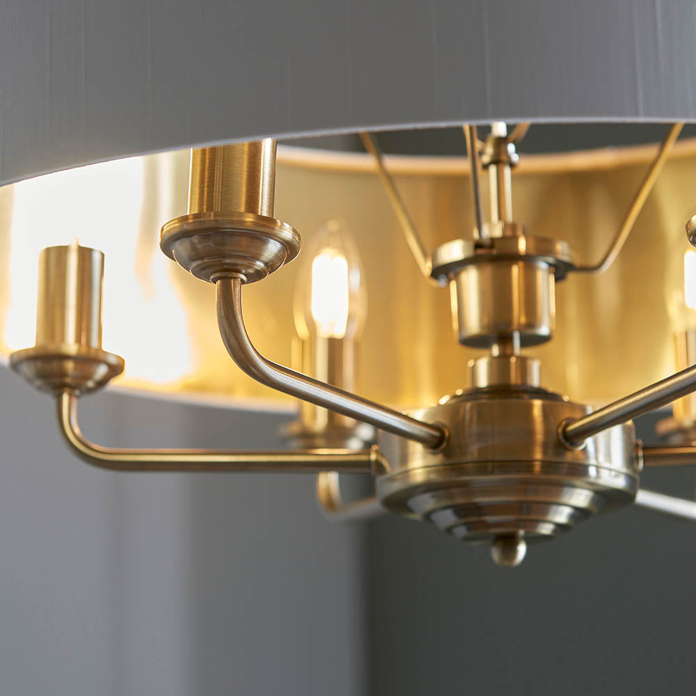 Close-up of Endon Brenley V1 6 Light Pendant showing antique brass arms, central fitting, and the gold-lined interior of the vintage white fabric shade.