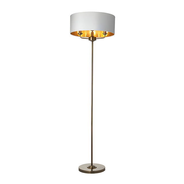 Endon Brenley 3 light floor lamp with wide white fabric shade, gold metallic inner lining and slim antique brass stem on a round base.