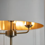 Close-up of Endon Brenley 3 Light Floor Lamp showing antique brass metalwork, three E14 lamp arms, and the gold-lined interior of the white fabric shade.