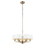 Brenley V2 6-light pendant with antique brass metal arms and chain, white fabric drum shades on each arm, shown on a plain white background.