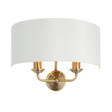 Endon Brenley 2 light wall light with a curved white linen half-shade on an antique brass twin-arm backplate, shown on a plain white background.