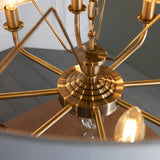 Close-up of the Endon Brenley 8 Light Pendant showing the antique brass central hub, spoked arms, and E14 candle lamp holders.