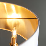 Close-up of Endon Brenley pendant showing gold-lined white fabric shade interior with lit E14 candle bulb on antique brass fitting.