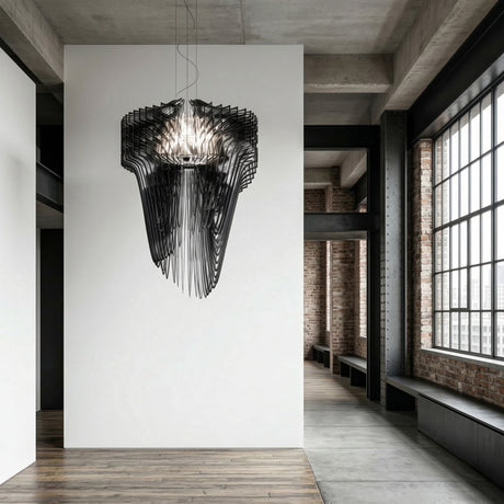 A modern, minimalist interior features the Aeris 5 Light Large Chandelier in black hanging from the ceiling, white walls, exposed brick, concrete floors, and tall industrial-style windows bringing in natural light.