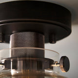 Close-up of the Endon Camden matt black flush ceiling light showing knurled thumbscrews, mesh bulb cage detail and clear glass shade rim.