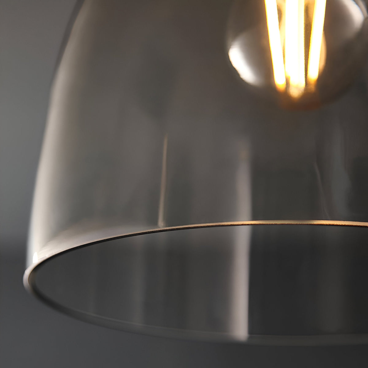 Close-up of the Endon Camden flush ceiling light showing the clear glass shade rim and glowing E27 filament bulb against a grey background.