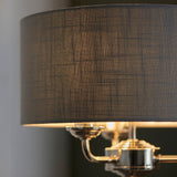 Close-up of Endon Brenley 3 Light Table Lamp showing charcoal grey linen-mix drum shade and polished nickel three-arm bulb holder.