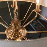 Close-up of the Endon Brenley 8 Light Pendant showing the antique brass central hub, ridged detailing, chain suspension and radiating arms with lit E14 lamps.