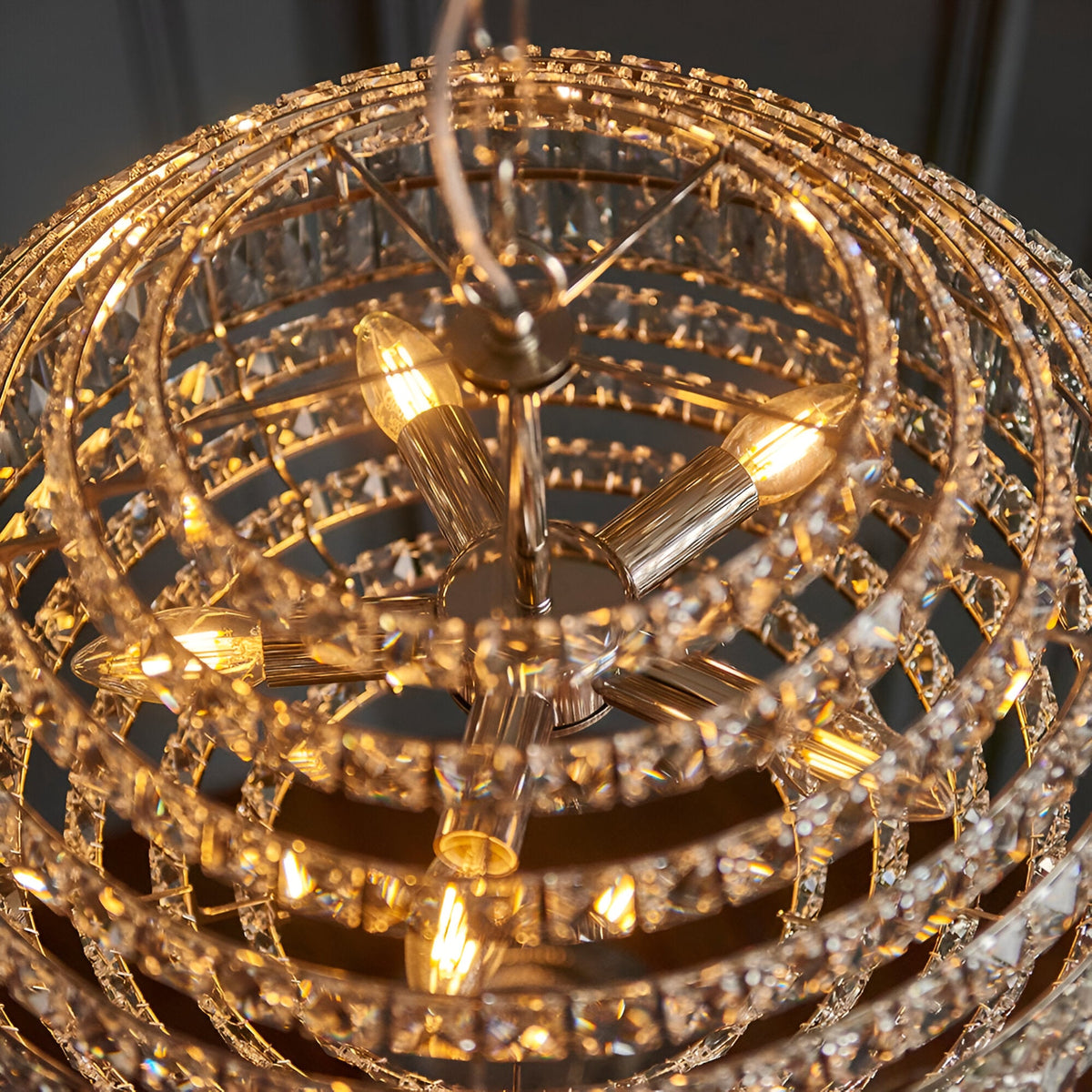 Close-up of the Endon Aldton 5 Light Pendant showing tiered rings of clear faceted crystals around polished nickel arms with lit E14 candle bulbs.