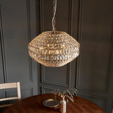 Endon Aldton 5 light pendant with rounded tiered crystal shade on polished nickel chain, hung above a wooden dining table against grey panelled walls.