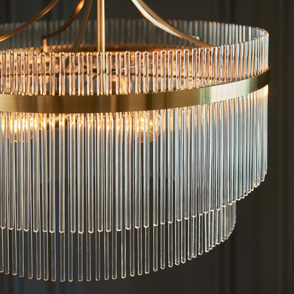 Close-up of the Endon Beaumont 5 Light Pendant in brass, showing tiered clear glass rods around a brushed brass band with lit E14 lamps inside.