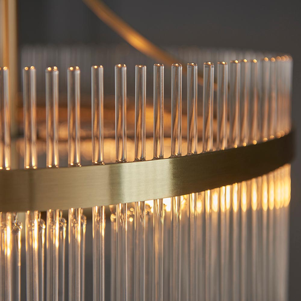 Close-up of the Endon Beaumont 3 Light Pendant in brass, showing the brushed brass band and vertical clear glass rods diffusing a warm glow.