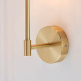 Close-up of the Endon Cliffhurst wall light showing its satin brass wall plate, slim upright and cylindrical fitting against a soft neutral background.