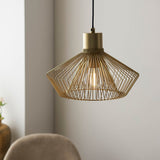 Endon Brockton cage pendant light in polished gold, with an open wire shade around an exposed filament bulb on a black flex, in a dining setting.