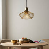 Endon Brockton gold cage pendant light with open metal shade and black flex, hanging above a wooden dining table set with bowls and a magazine.