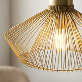 Endon Brockton cage pendant light in polished gold, wide flared metal wire shade with visible E27 filament bulb, shown lit in a softly blurred interior.
