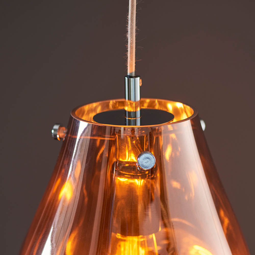 Brackwell Glass Pendant in Copper, close-up of the cone-shaped molten glass shade with chrome fittings and light grey fabric cable, lit E27 bulb visible inside.