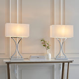 Endon Brackton chrome table lamps as a twin pack with curved metal bodies and white rectangular fabric shades, styled on a marble console table.