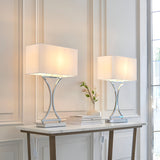 Endon Brackton chrome table lamps twin pack with curved metal stems and white rectangular fabric shades, styled on a marble console table.